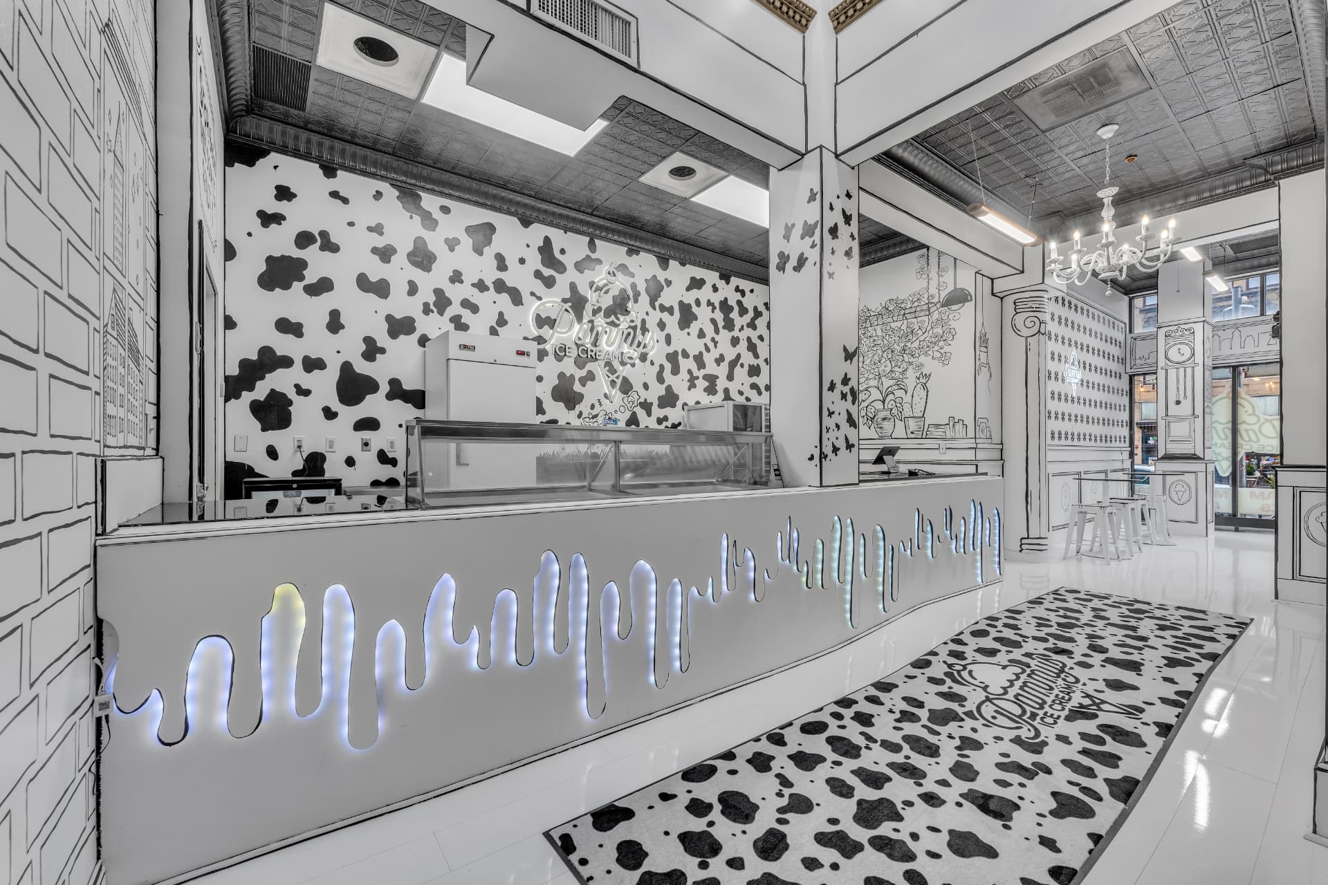 Pammy's counter with glowing drip lighting, cow-print runner and the neon Pammy's Ice Cream sign